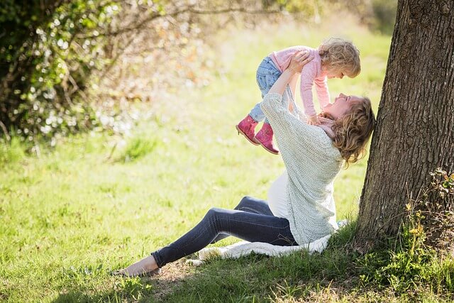 お母さんが子供を抱き上げて笑っている写真