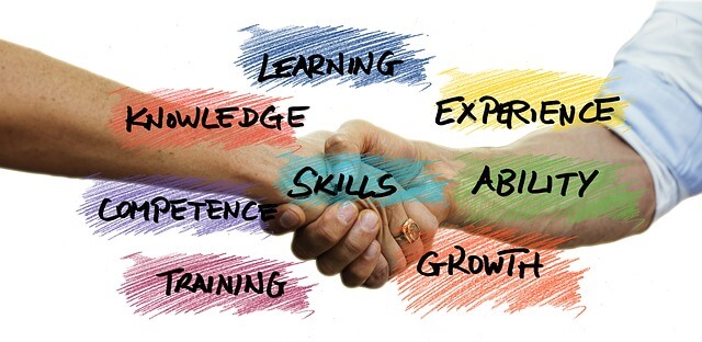 二人が握手している写真 文字は learning knowledge skills ability competenc growth などが書いてある